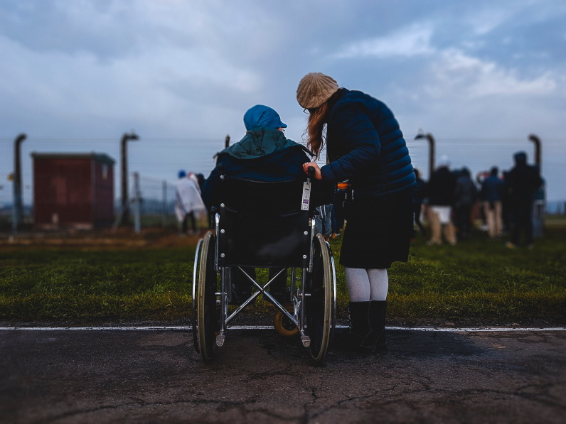 women standing next to another woman in a wheelchair