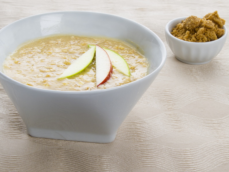 bowl of oatmeal with sliced apple and brown sugar