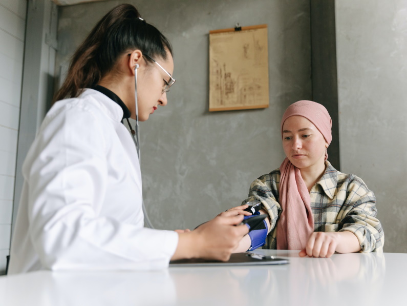 doctor speaking with a young cancer patient about her progress