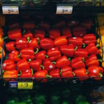 grocery aisle of bell peppers in red, orange, and yellow