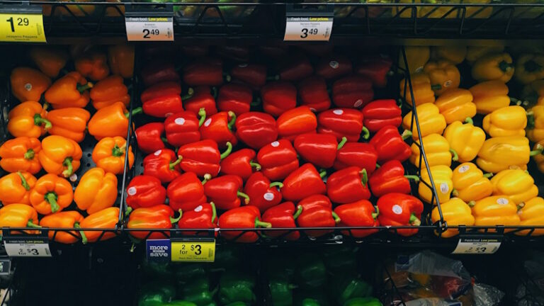 grocery aisle of bell peppers in red, orange, and yellow